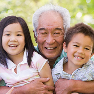 Photo of a grandfather and children smiling.